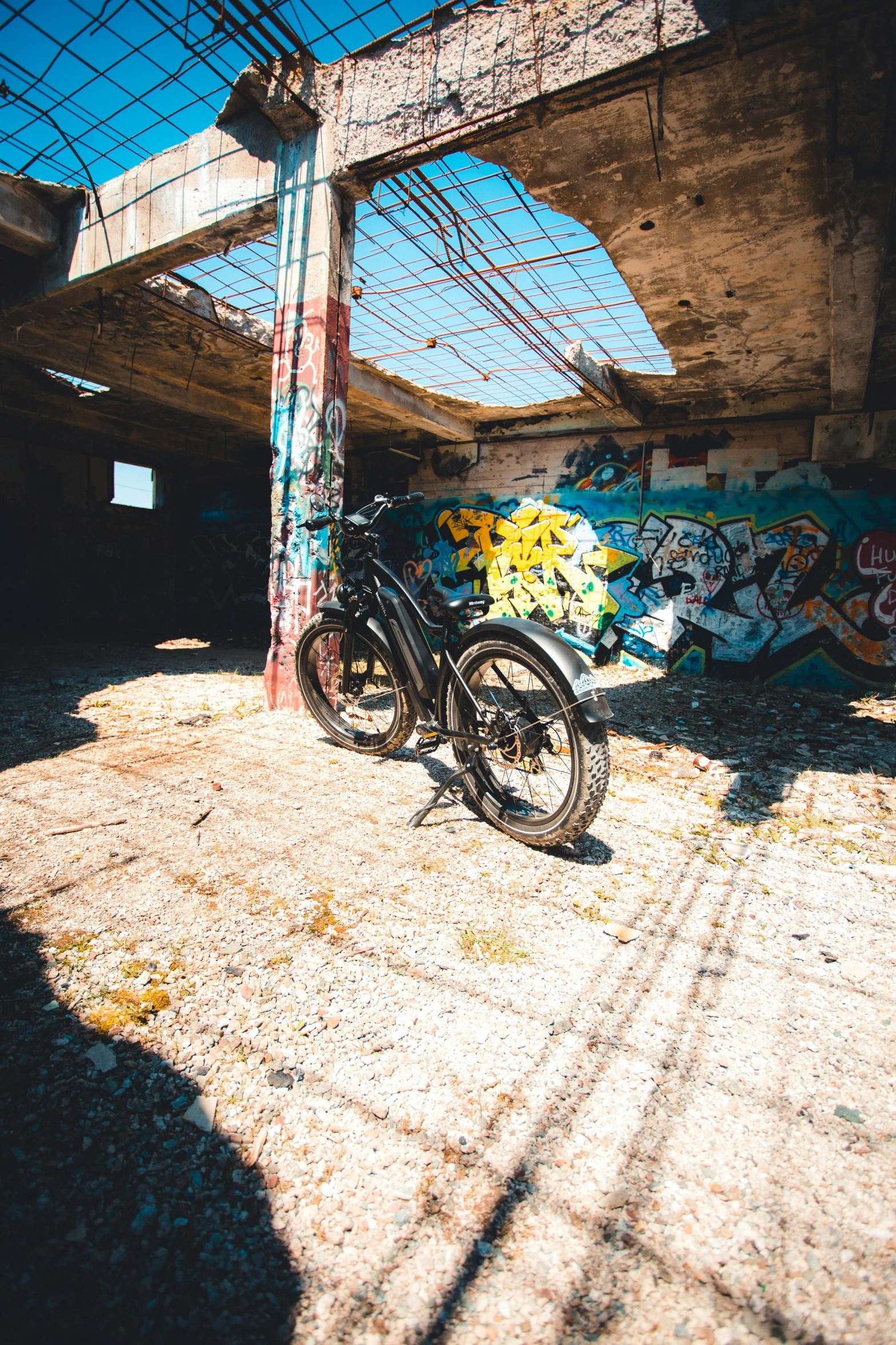 a bicycle parked under an overpass on a street