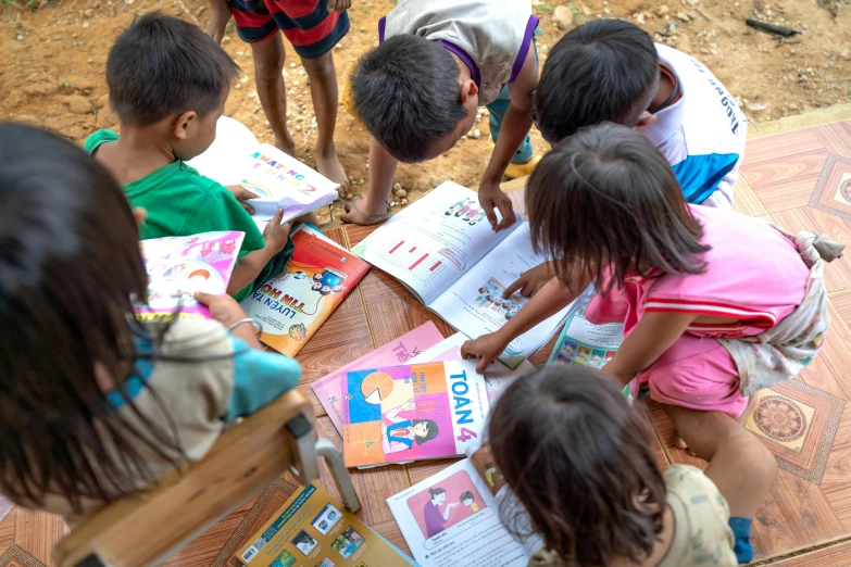 a group of children are looking at a picture on a table