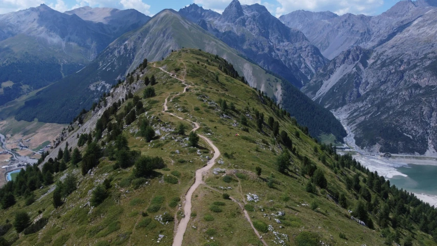 an aerial view of the mountains with a dirt road