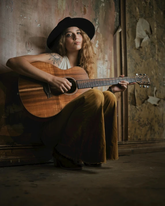 a woman with a hat playing a guitar