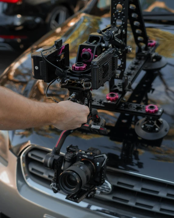 someone working on a small device in front of a car