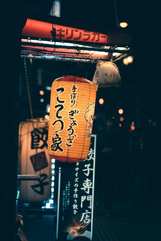 an orange lantern hanging from a ceiling at night