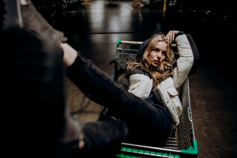 a  hing a shopping cart while she has her arm behind her head