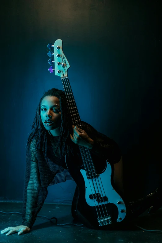 a woman with dreadlocks is playing a guitar