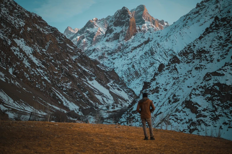 a man in the middle of the mountain with snow on mountains