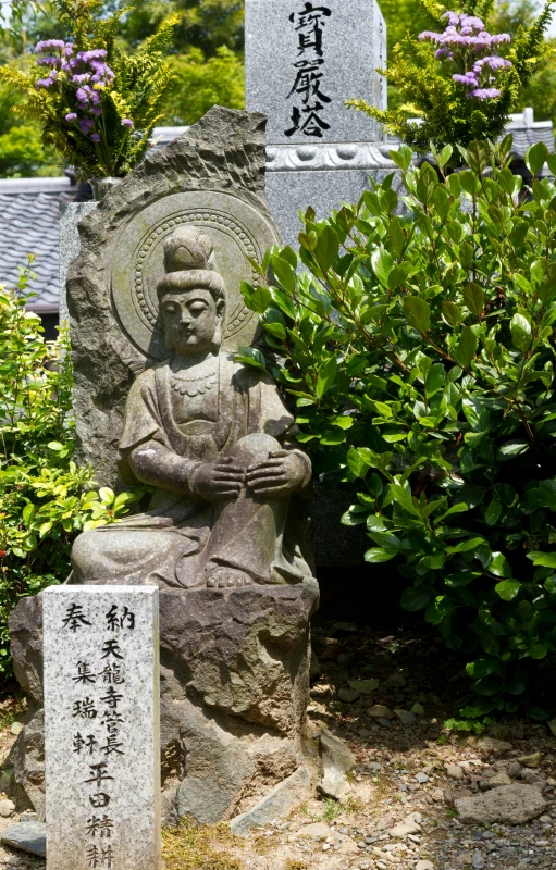 a stone statue with chinese writing on it and trees in the background