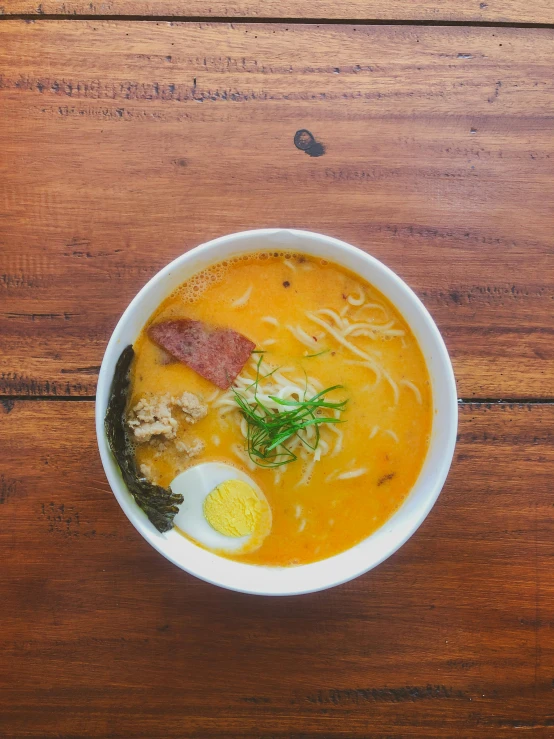 a bowl of soup with an egg on top
