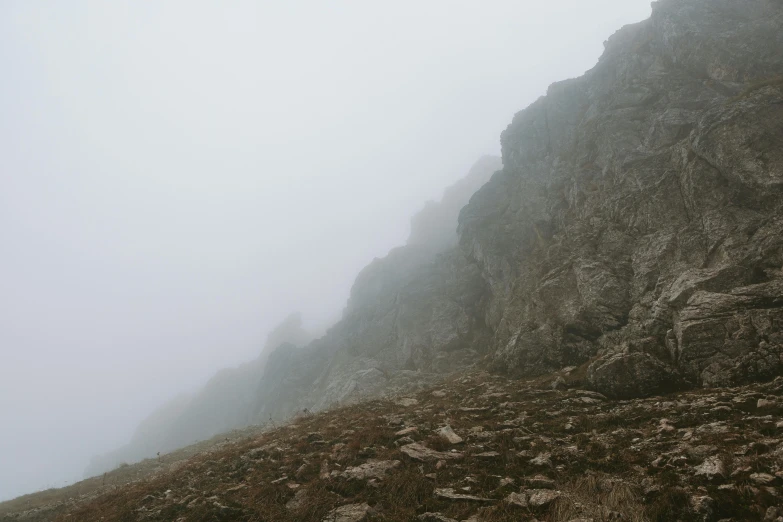 some very tall mountain side cliffs with fog