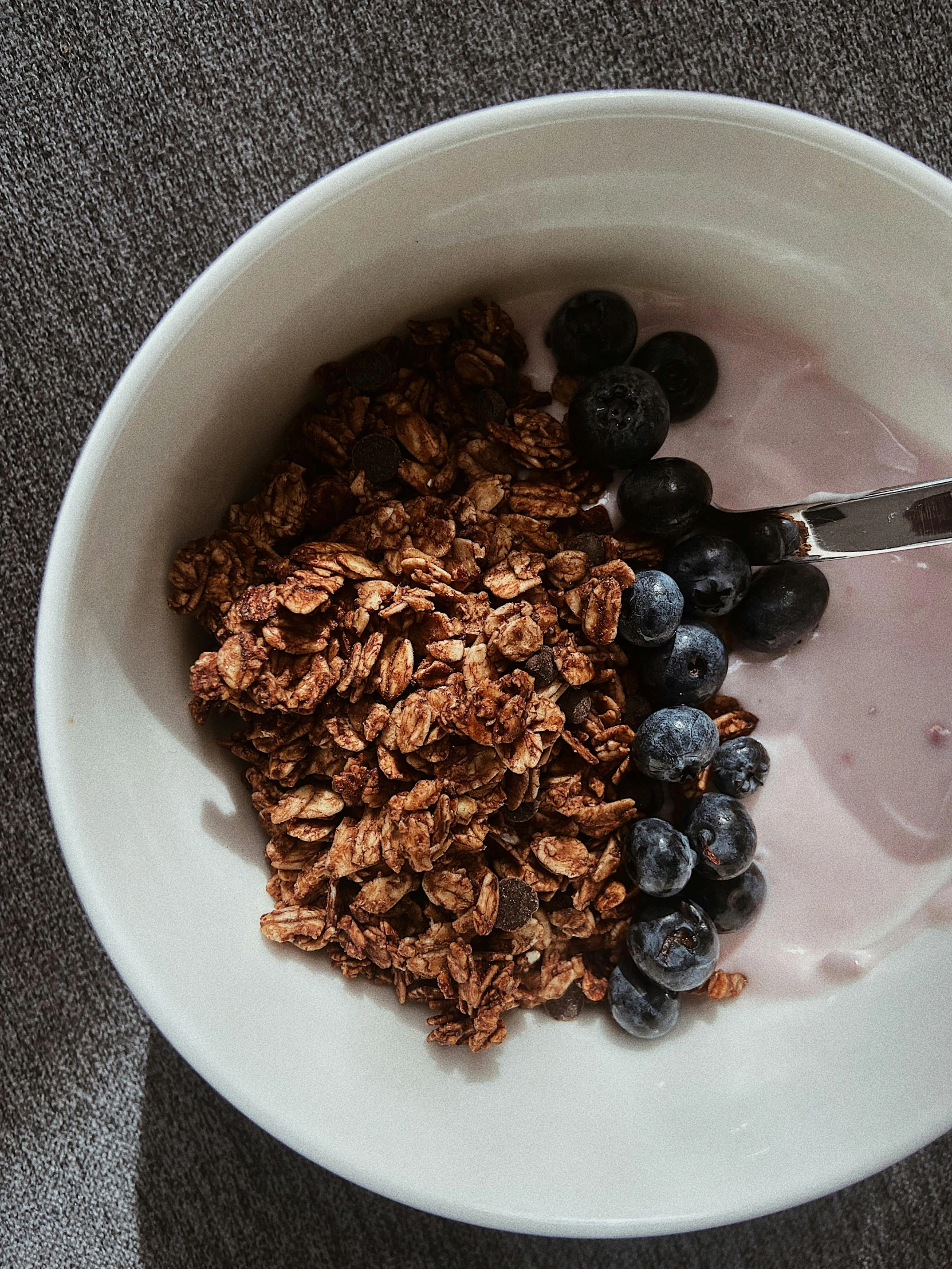 the bowl is full of granola and fresh blueberries