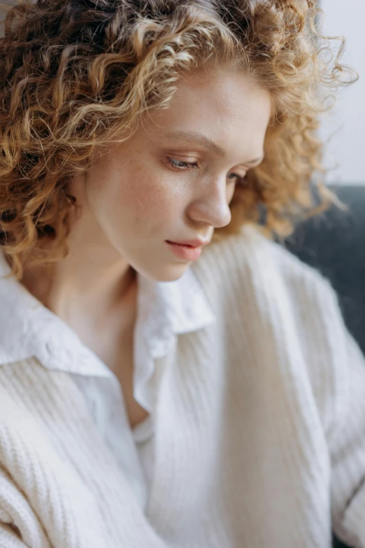 a woman with curly hair looking down while typing