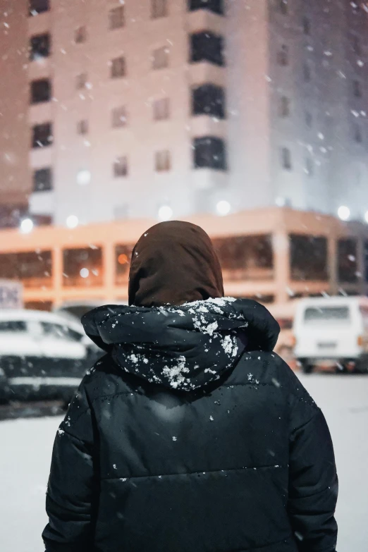 a person is standing in front of a building and cars