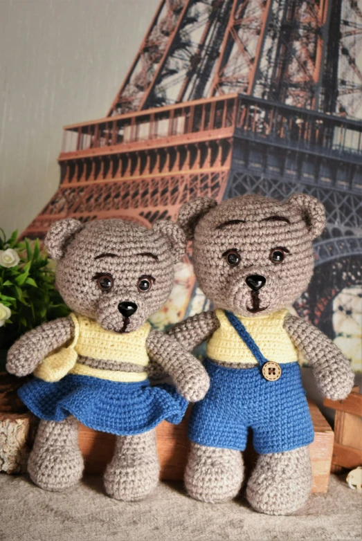 crochet teddy bears dressed up and posed by the eiffel tower