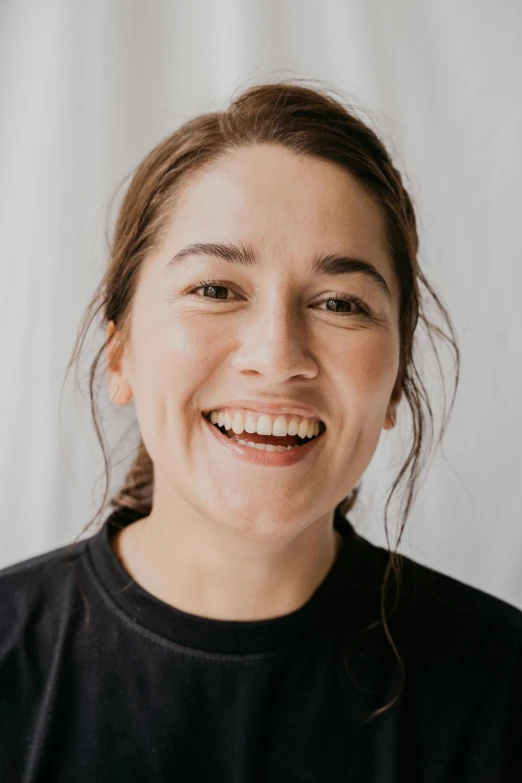 a woman smiling for a po with a white background