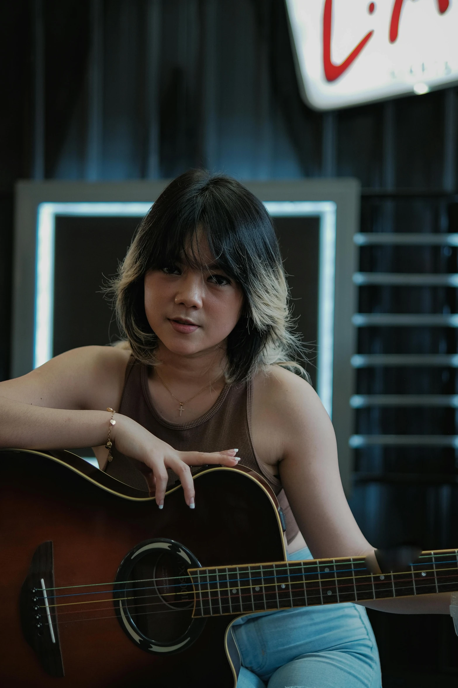 a woman sitting on the ground holding a guitar