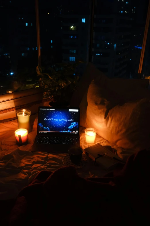 a couch and table with candle lit candles in front of a laptop