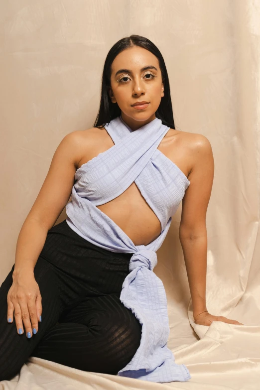 a woman wearing a dress posing in front of a white backdrop