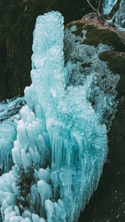 a close up of a frozen rock near water