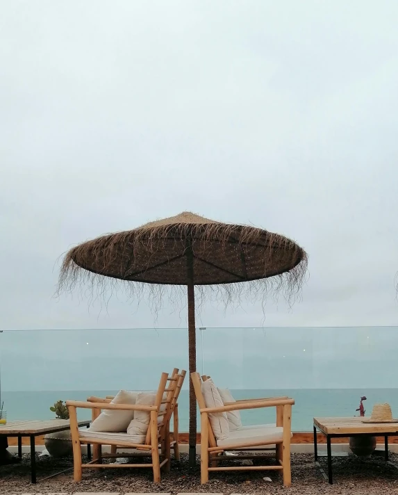 a beach area with patio furniture and an umbrella