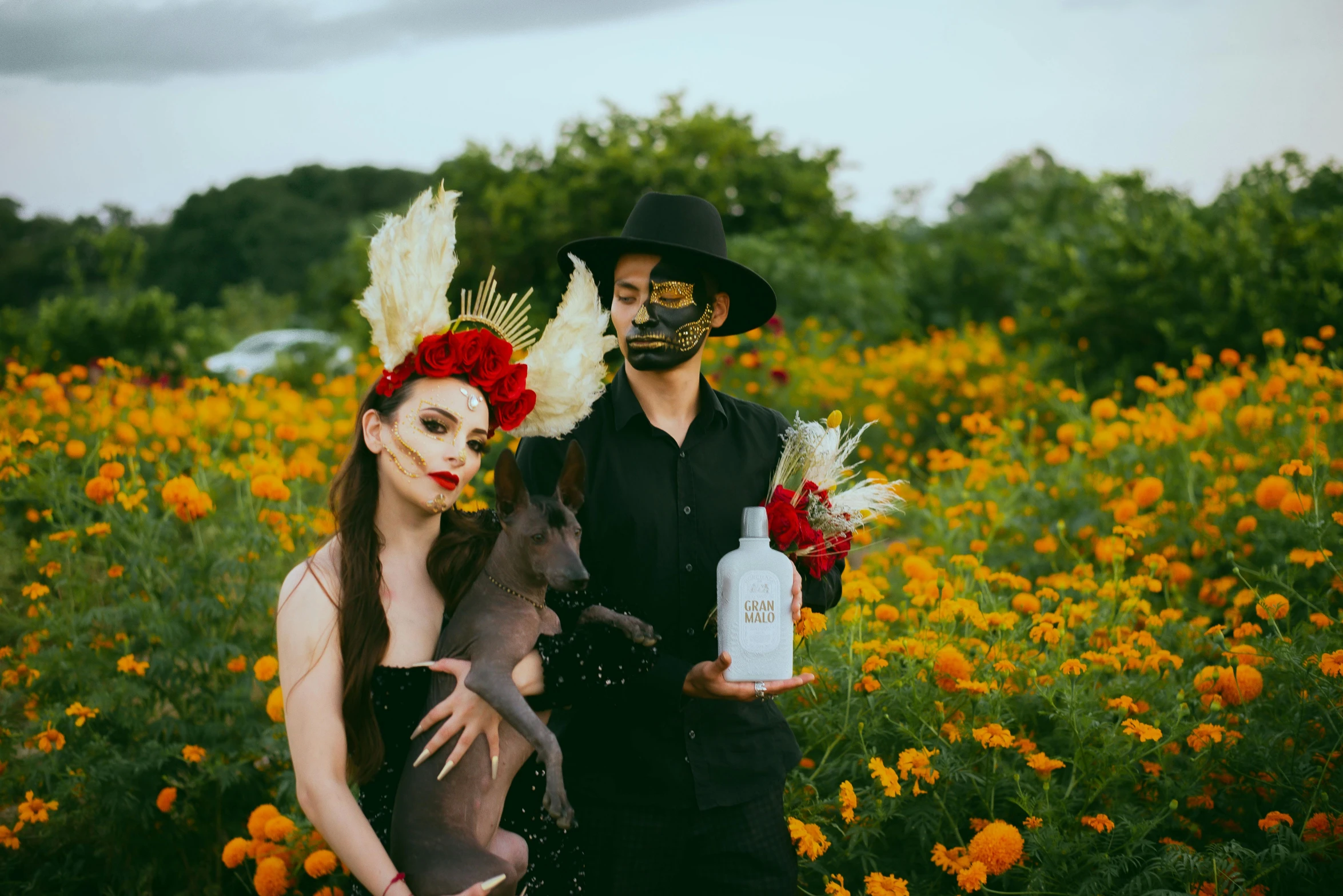 couple dressed in costumes posing for picture with a bottle