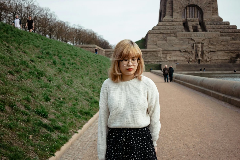 woman in a skirt and sweater posing for a picture