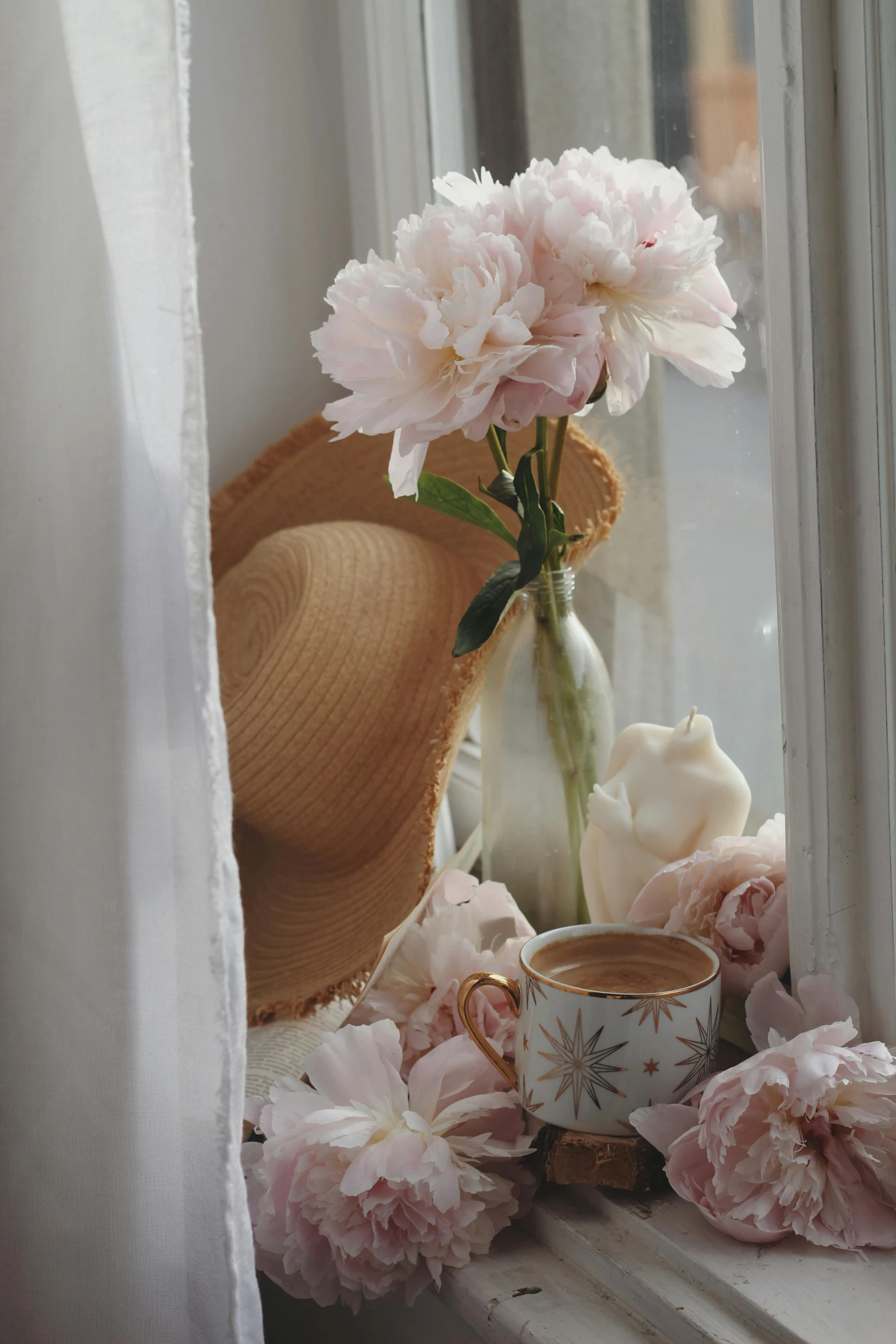 a vase with pink flowers and a tea cup next to it
