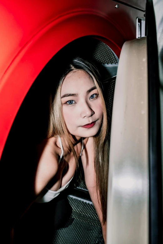 young lady looking down at the ground from the side of an electric train