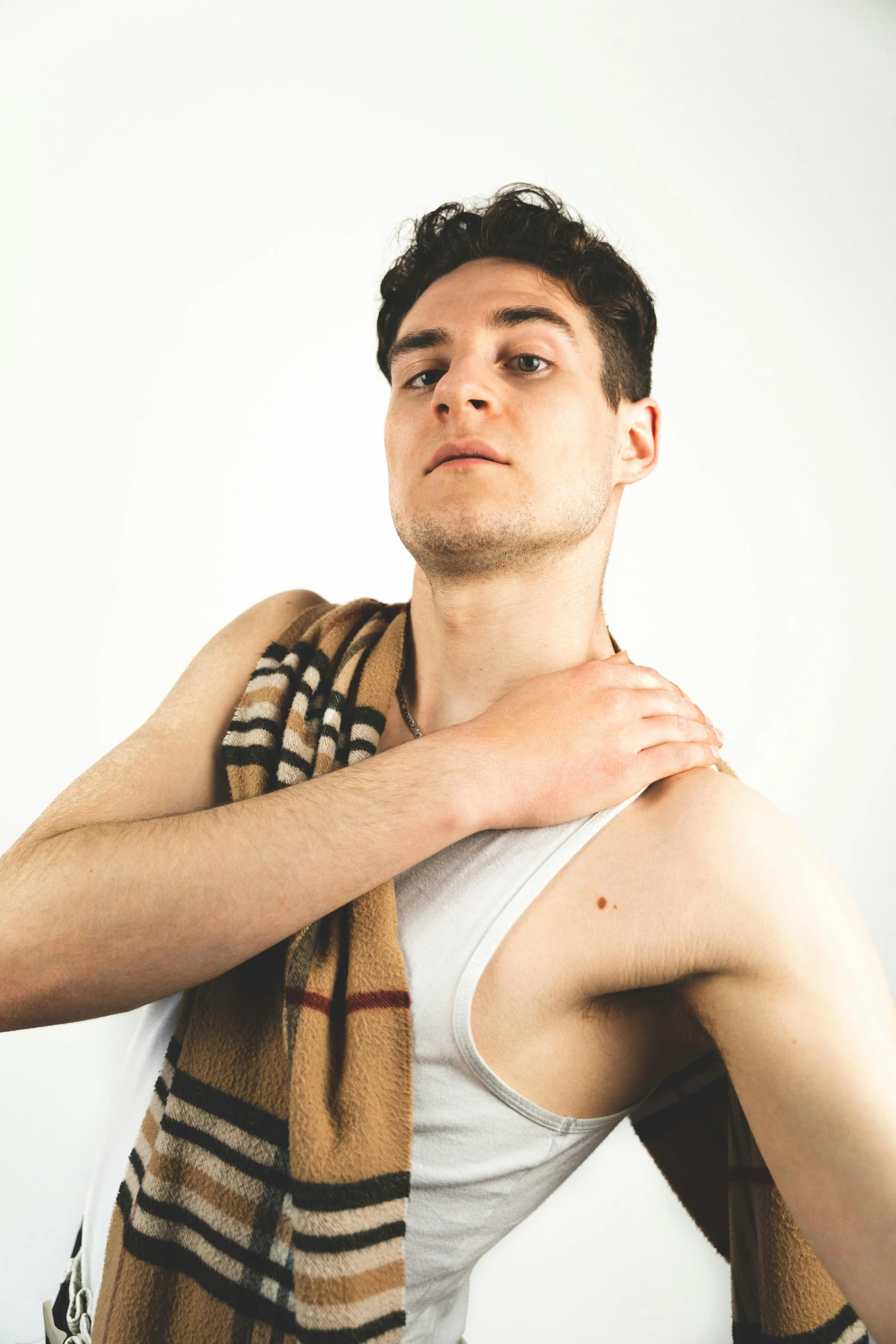 a young man in a tank top posing for a portrait