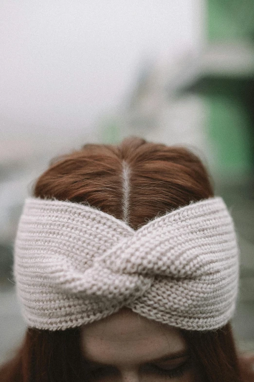 a woman wearing a white knitted headband