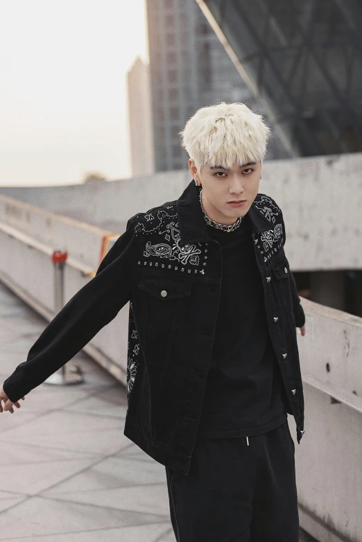 a male with a white hair wearing a jacket and black pants