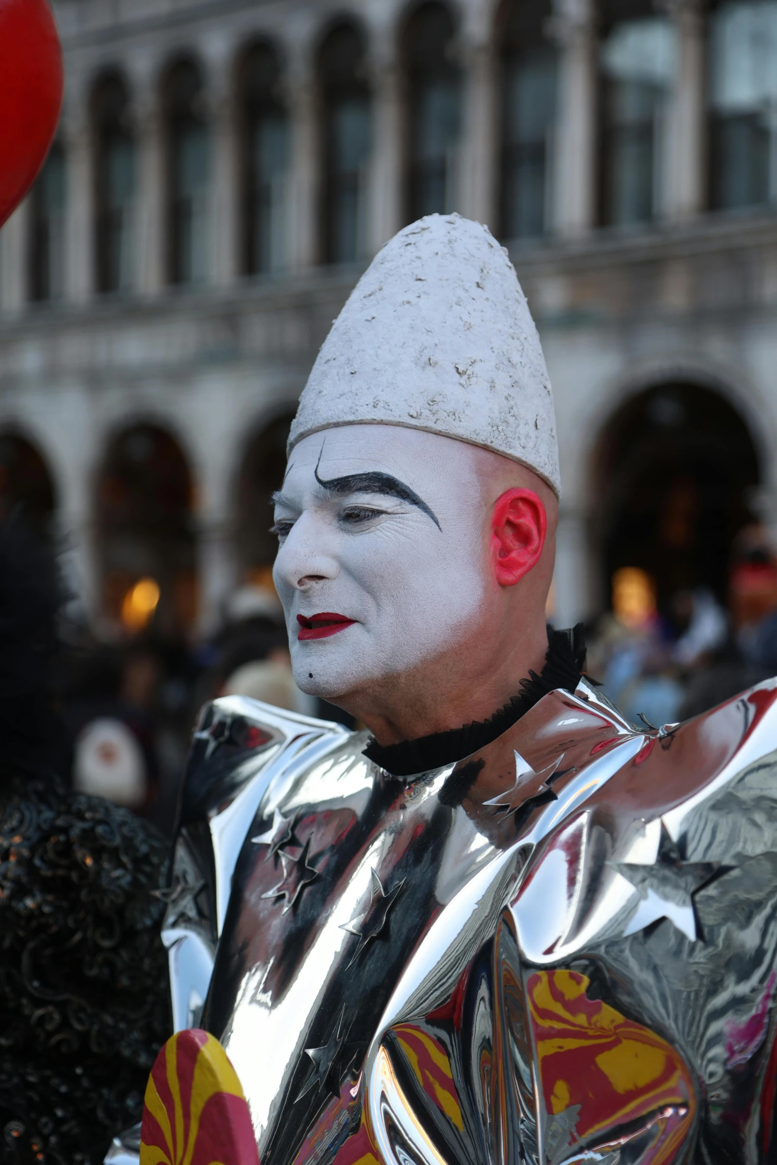 an inflatable mask stands amongst some other people