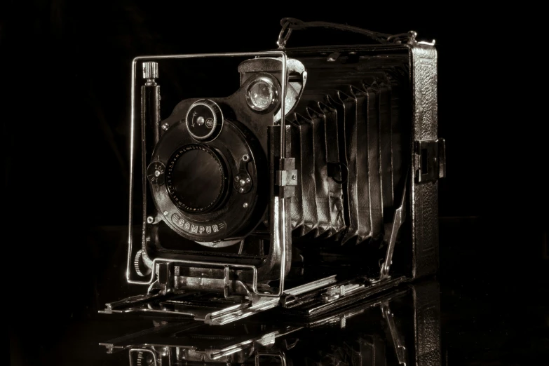 an antique camera that is sitting on some glass