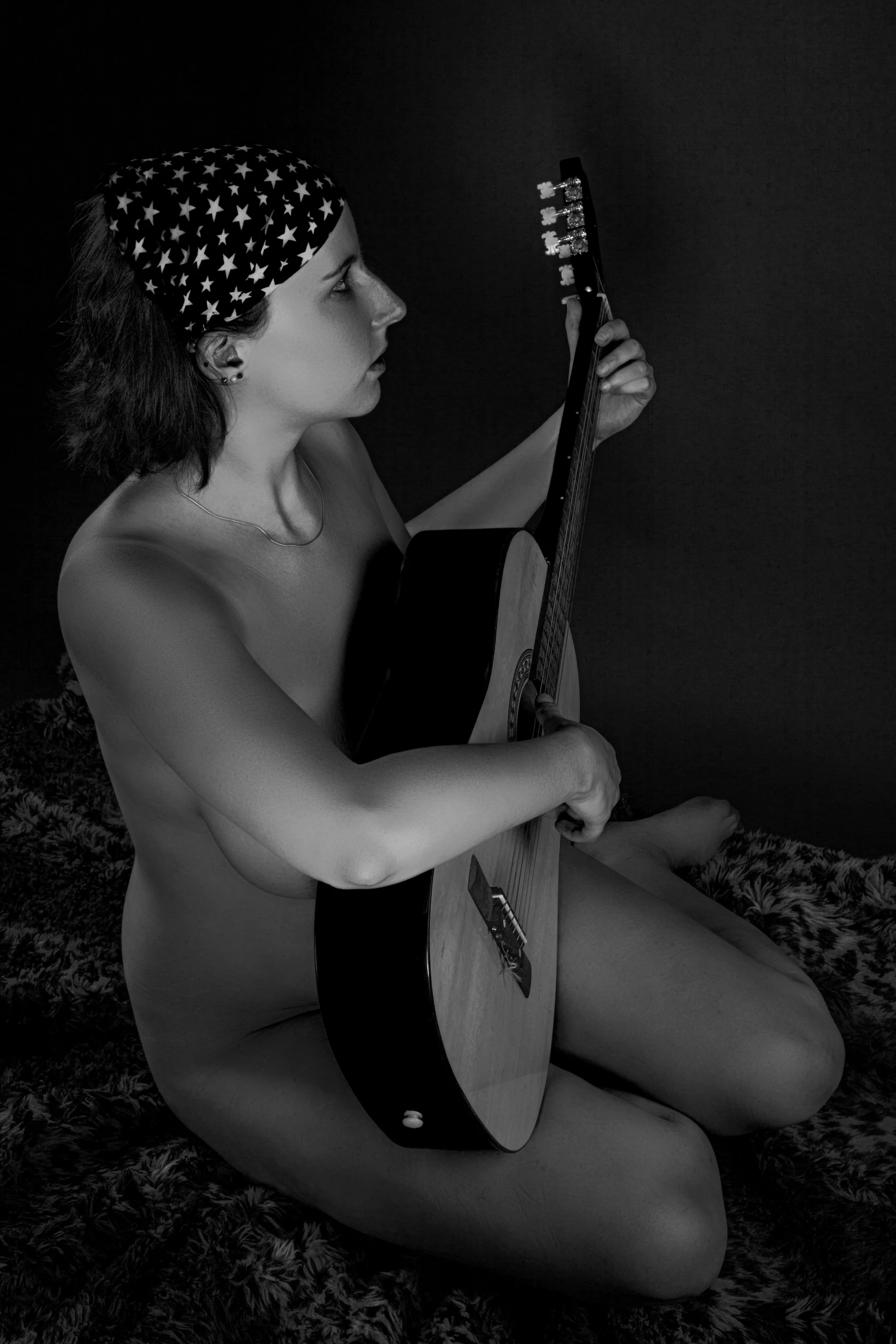 a girl with a head bandanna holding a guitar