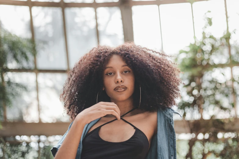 a woman with long curly hair wearing a black top