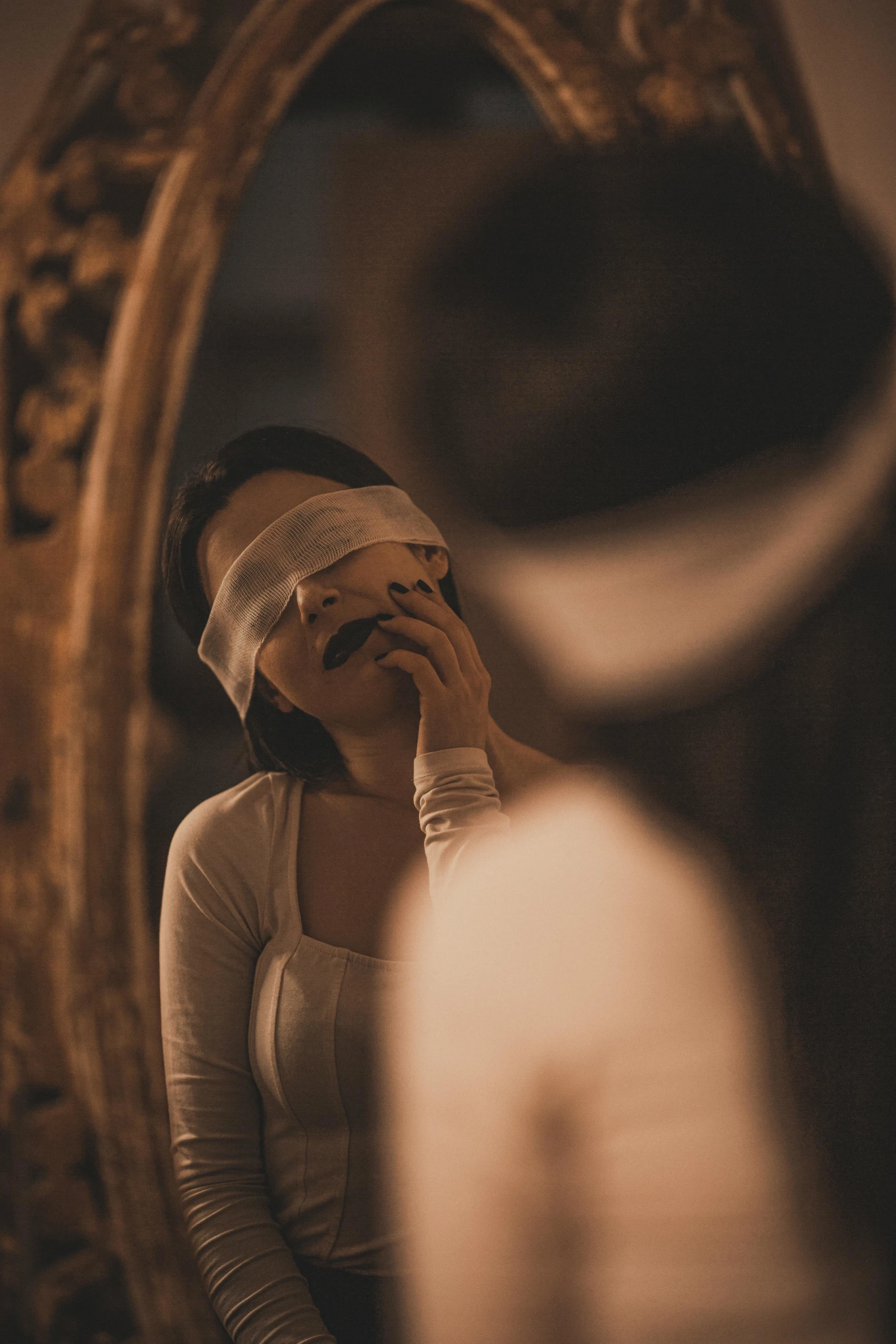 a woman standing in front of a mirror while looking at herself