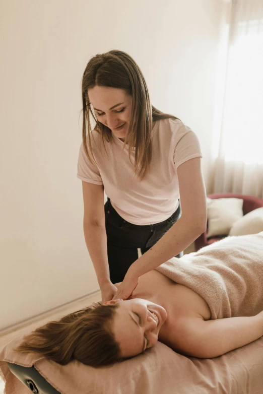 a woman in a pink shirt getting a massage