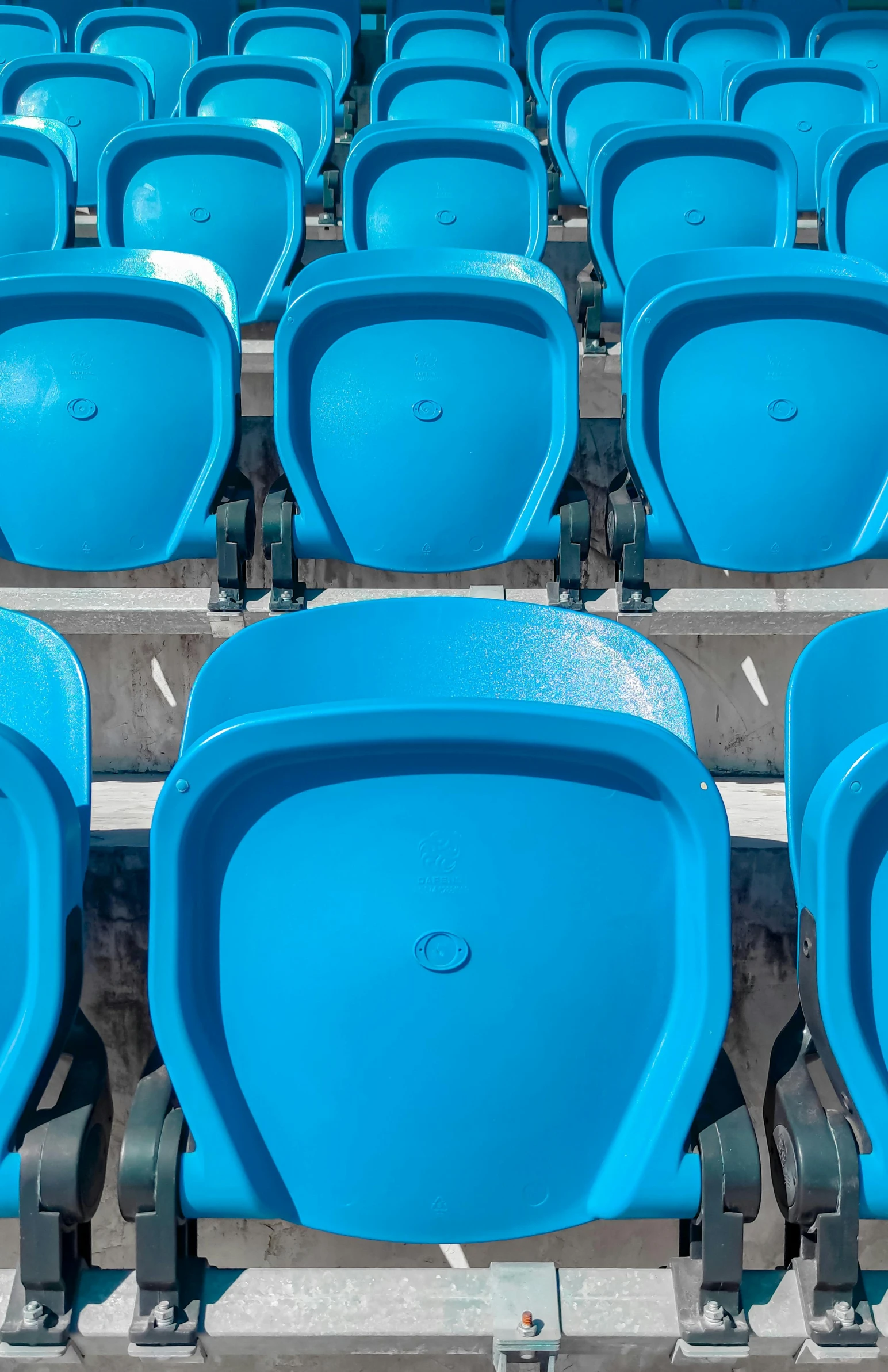 blue seats are arranged in rows on a stadium