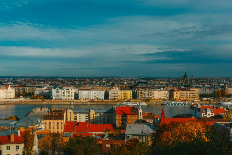 a city next to the water under a cloudy blue sky