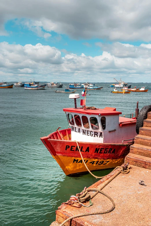 a boat sitting on the water with boats in the background