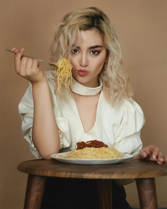 the woman is eating spaghetti on a plate