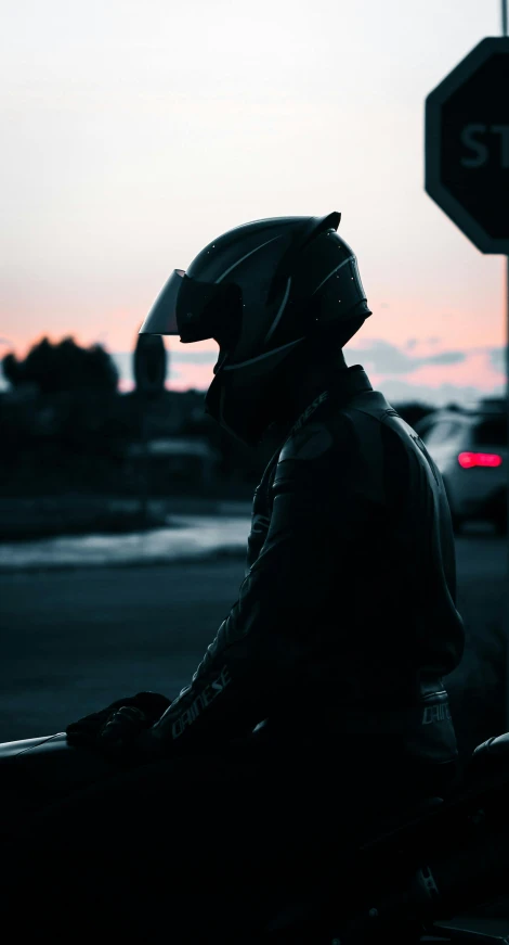 the man is dressed in motorcycle gear at sunset