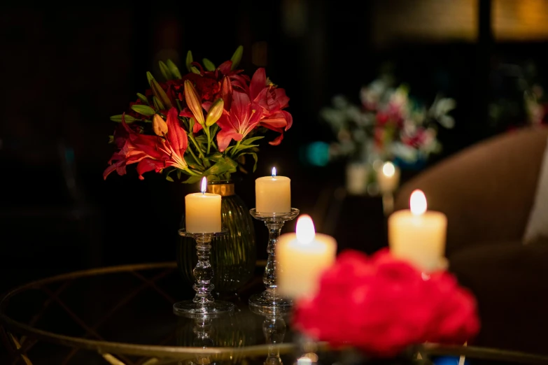 candles are set out on a table with flowers in a vase