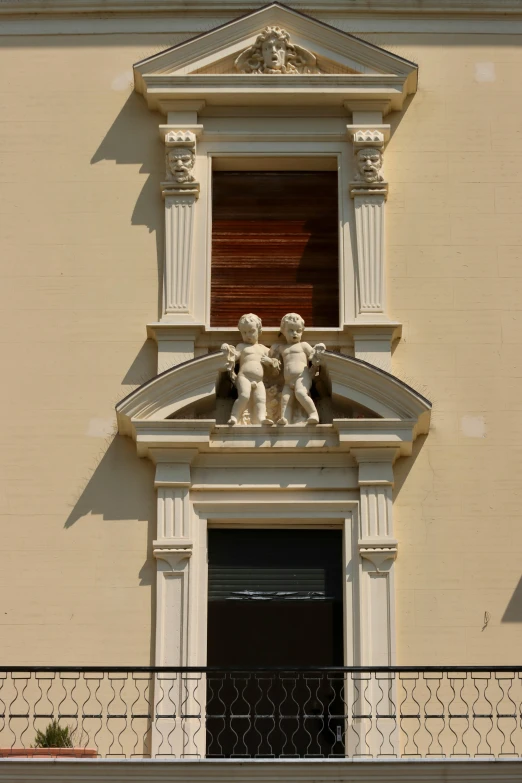 two sculptures on a window ledge with a balcony