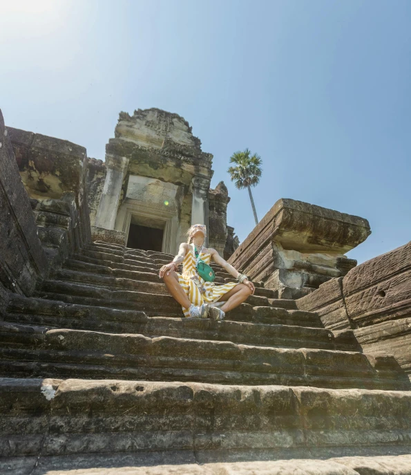 a man sits on the top of steps in front of a castle