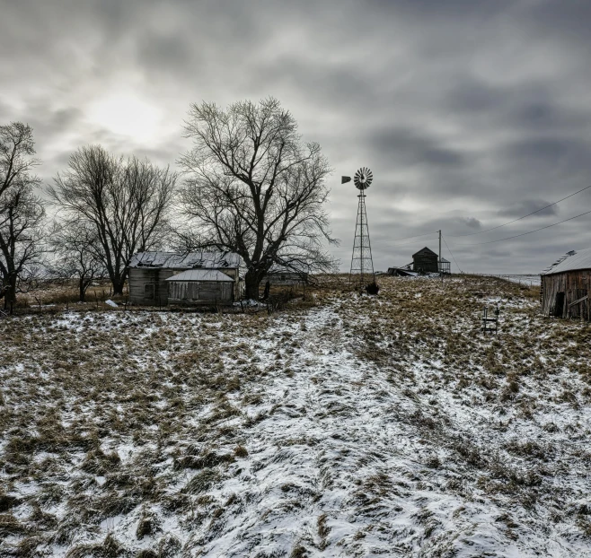 an image of old buildings and a dirt hill covered in snow