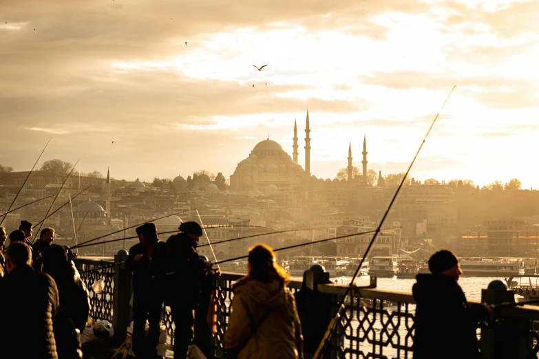 people standing on a bridge with fishing rods