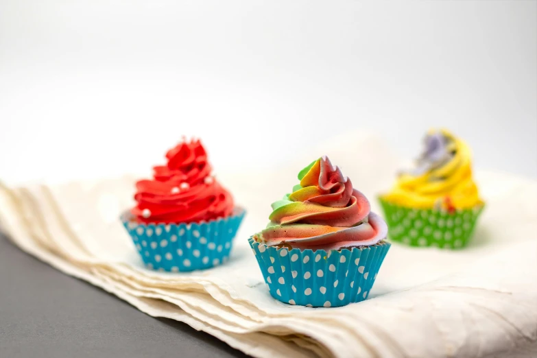 three cupcakes on a napkin sitting on a counter