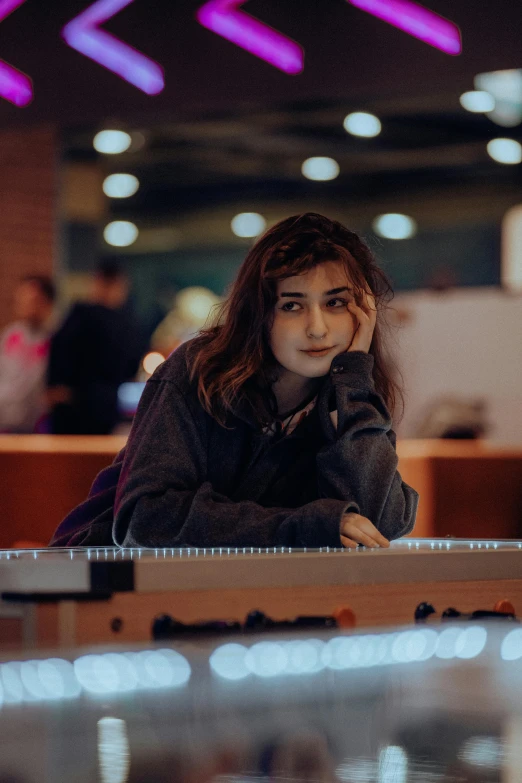 a girl is sitting at a table with her laptop