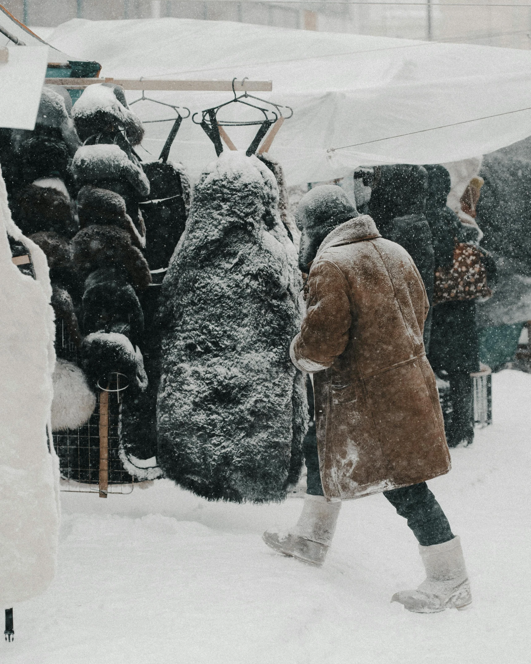 a woman wearing a coat and boots is walking through snow