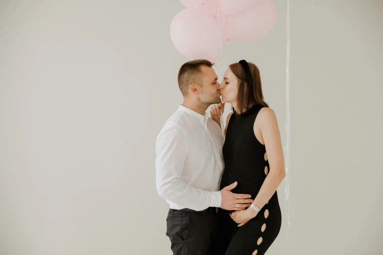 an image of a couple kissing with a balloon