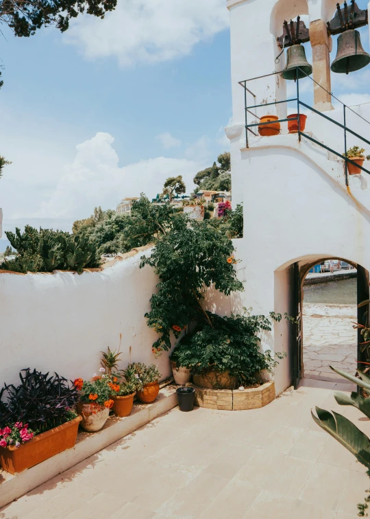 an outside s of potted plants in front of a bell